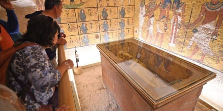 سائحون ينظرون إلى التابوت الذهبي لملك الأسرة الـ18 الفرعون توت عنخ آمون (1332-1323 قبل الميلاد) في حجرة دفنه تحت الأرض بمدينة الأقصر جنوبي مصر