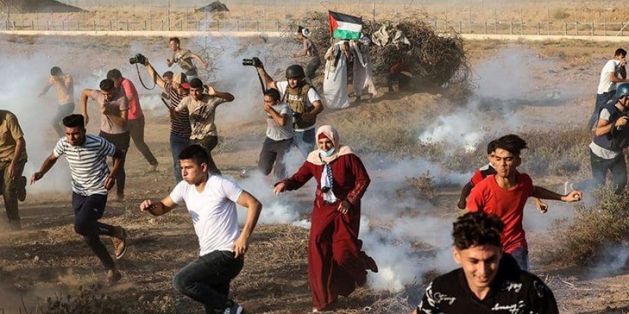 متظاهرون فلسطينيون وصحفيون يفرون من قنابل غاز المسيلة للدموع