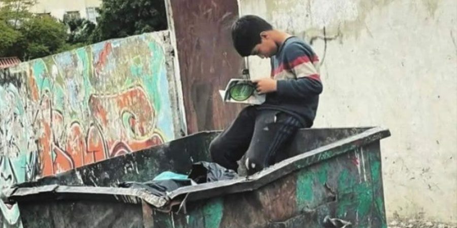 صورته واقفًا في مكب القمامة، ممسكا كتابًا انتشله من بين النفايات