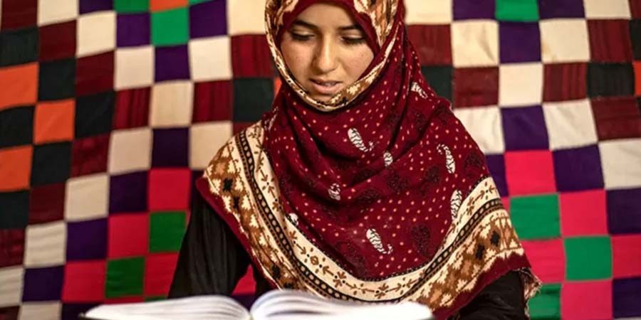 امرأة تقرأ القرآن في مخيم الكبش للنازحين في منطقة ريفية بالقرب من مدينة الرقة، شمالي سوريا، مع بدء شهر رمضان.