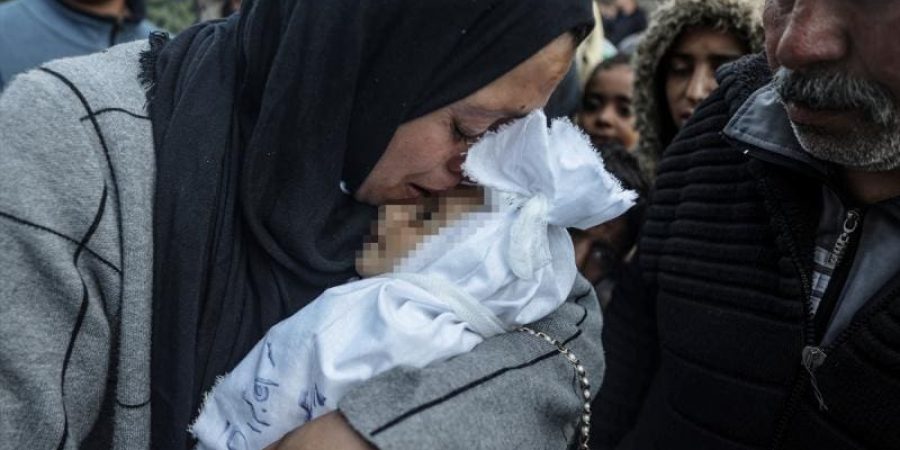 فلسطيني يحمل جثمان حفيده