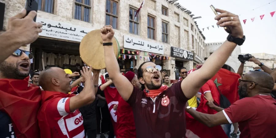 المشجعون يحرصون على التقاط الصور وسط مباني سوق واقف.